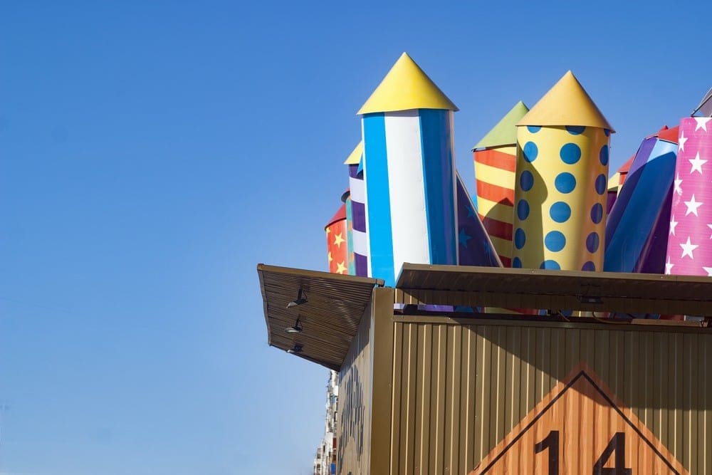 Large, colorful rocket-shaped structures with patterns are partially visible above a brown building.