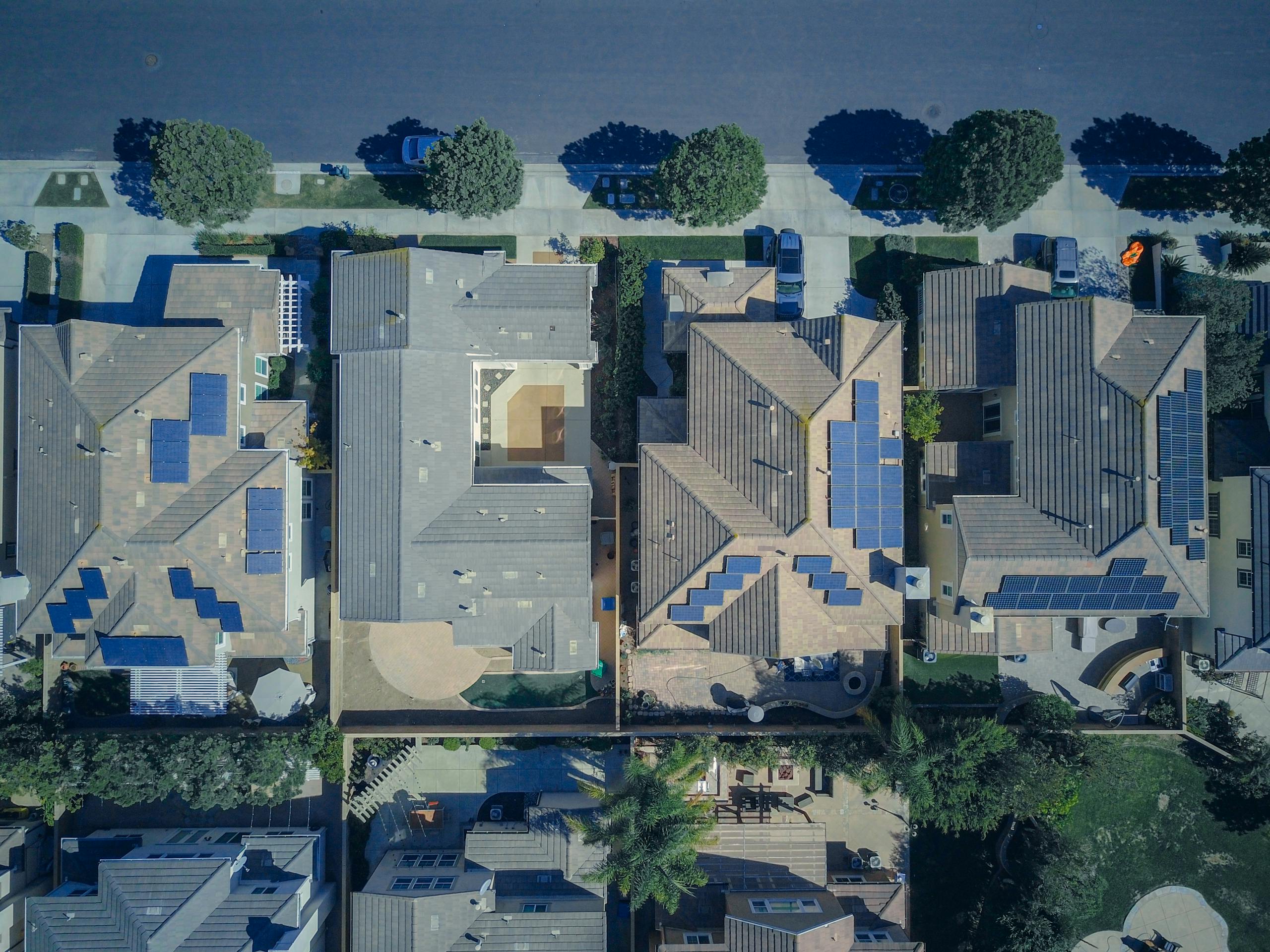 Top-down view of urban houses with solar panels.