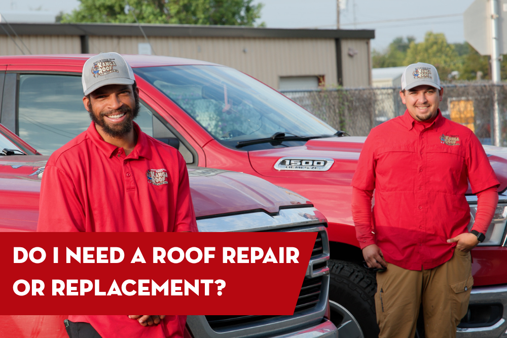 Two roofing professionals in red uniforms and hats stand in front of red work trucks, smiling, with a banner that reads “Do I need a roof repair or replacement?”
