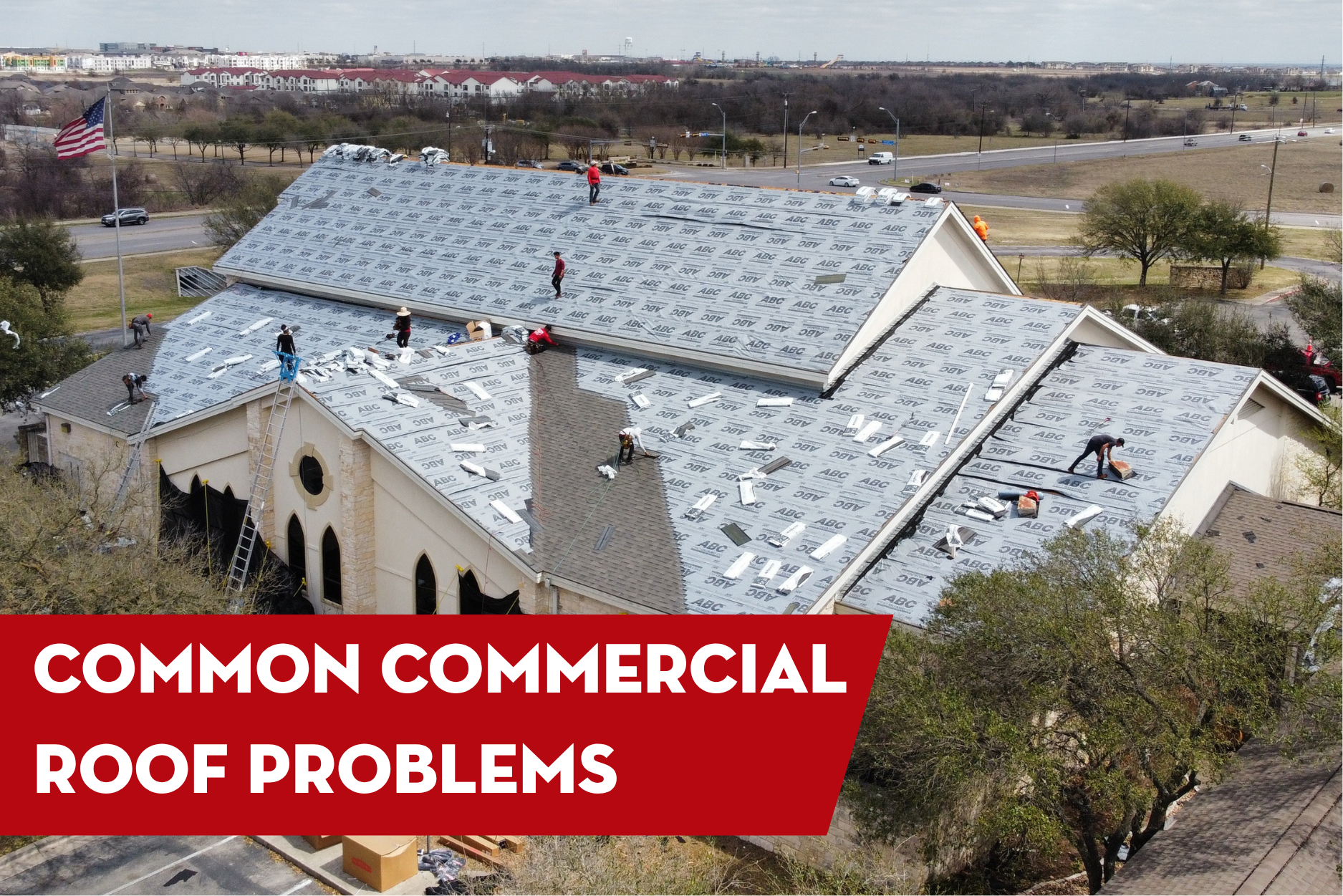 Commercial roofing crew installing underlayment on a large building roof, highlighting common commercial roof problems and repair solutions